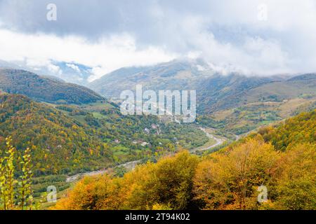 Ruhige und ruhige Atmosphäre mit schwungvollen weißen Wolken, die sich anmutig über die lebendigen und vielfältigen Herbstberge bewegen und die Schönheit von zeigen Stockfoto