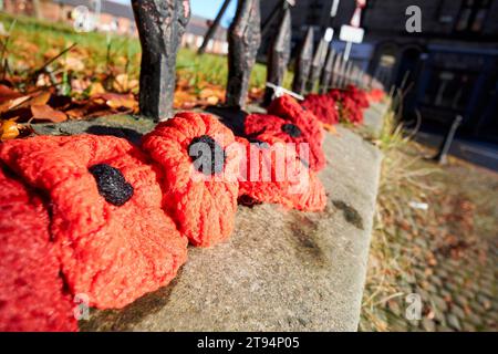 Eine Reihe gestrickter Mohnblumen vor einer Kirche zum Gedenken am sonntag in ormskirk, lancashire, england, großbritannien Stockfoto