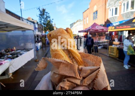 Spaziergang mit Wurstbrötchen an Marktständen im Winter an einem samstagtag in der Marktstadt ormskirk, lancashire, england, großbritannien Stockfoto