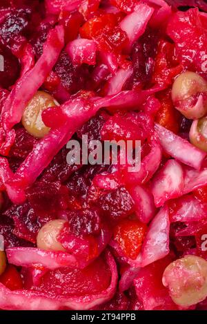 Köstlicher saftiger Vinigret-Salat aus gekochtem Gemüse Kartoffeln, Rüben, Topf, Kohl und Karotten mit Salz und Gewürzen auf dunklem Betonhintergrund Stockfoto