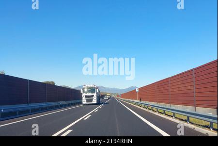 Schalldämmende Lärmschutzwand auf der Autobahn zum Schutz vor Lärmemissionen von Fahrzeugen in der Nähe des Stadtzentrums Stockfoto