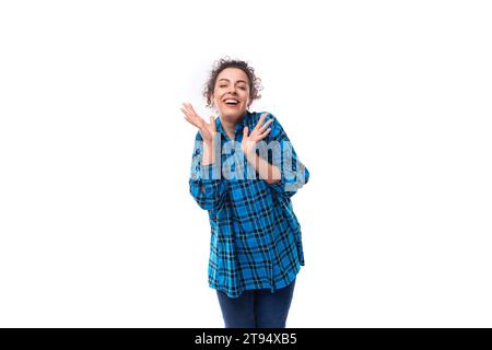 europäisch freundliche junge Dame mit lockiger Pferdeschwanz-Frisur in einem blauen Hemd mit Karomuster Stockfoto