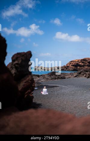 Junge Frau am Strand El Golfo (Playa el Golfo) auf Lanzarote, Kanarischen Inseln, Spanien Stockfoto