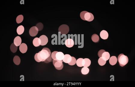 Pinkfarbene, unscharfe Bokeh-Lichter überlagern sich. Rosafarbenes Bokeh für das Design. Stockfoto