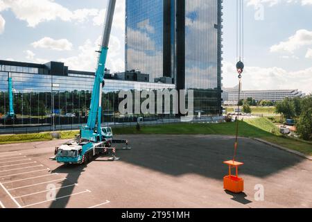 Blick aus der Höhe des Fahrzeugs auf einen schweren Kran mit Wiege, der auf dem Parkplatz geöffnet und einsatzbereit ist. Der höchste Lkw-Kran ist ausfahrbar Stockfoto