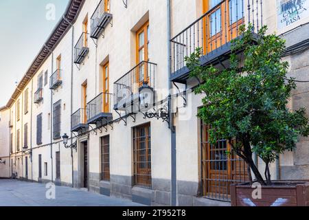 Moderne schmale spanische Straße in Madrid, Spanien, mit gekacheltem Namen „Calle de la Pasa“ (Übersetzung: Rosinenstraße) mit Balkonen, Fenstern mit Bars. Stockfoto