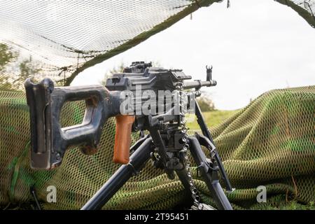 Sowjetisch gefertigte PK-Maschinenpistole und Tarnnetze. Kalaschnikows Maschinengewehr Stockfoto