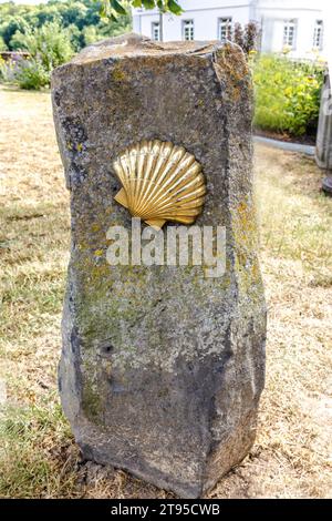 WEILBURG, DEUTSCHLAND - 28.06.2023 - Goldenes Muschelsymbol des Lahn-Weges auf einem großen Steinsockel in Weilburg, Hessen, Deutschland Stockfoto