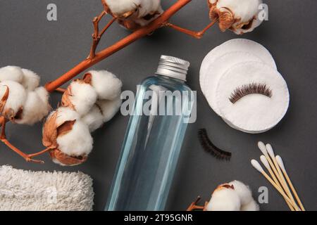 Flache Lay-Zusammensetzung mit Flasche Make-up-Entferner auf grauem Hintergrund Stockfoto