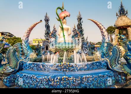 Aqua gefliester Pool mit kleinen Springbrunnen, bei Sonnenuntergang, umgeben von dekorativen blauen, grauen und goldenen Ornamenten, komplizierten Detailgravuren, Skulpturen und Stockfoto