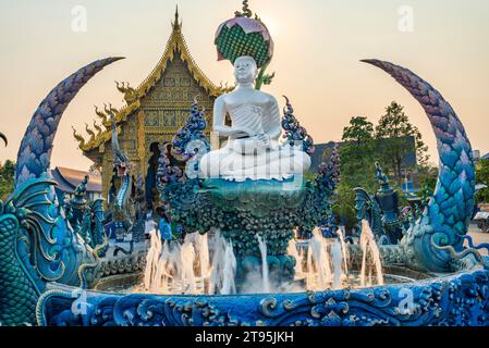 Aqua gefliester Pool mit kleinen Springbrunnen, bei Sonnenuntergang, umgeben von dekorativen blauen, grauen und goldenen Ornamenten, komplizierten Detailgravuren, Skulpturen und Stockfoto