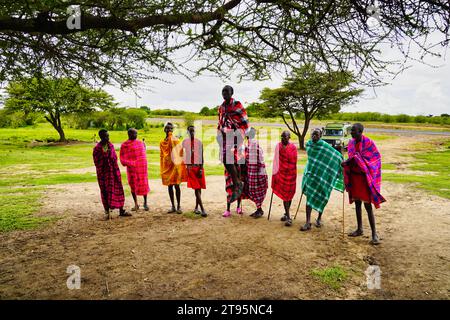 Maasai Mara, Kenia, 25. Dezember 2020 - Eine Gruppe junger Maasai-Krieger spielt ein traditionelles Lied und zeigt ihre Leichtathletik durch Stehen Sprünge Stockfoto