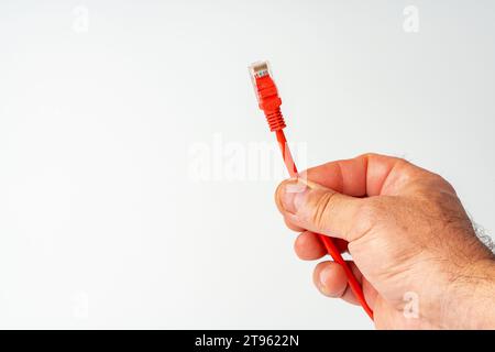 Die Hand des Mannes hält ein Internetkabel auf weißem Hintergrund Stockfoto