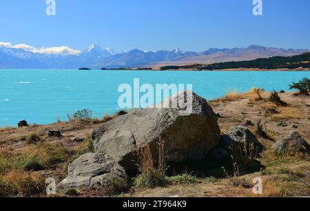 Mount Cook an einem sonnigen Sommertag über die felsige Küste des türkisfarbenen Sees tekapo, nahe Twizel, auf der Südinsel neuseelands Stockfoto