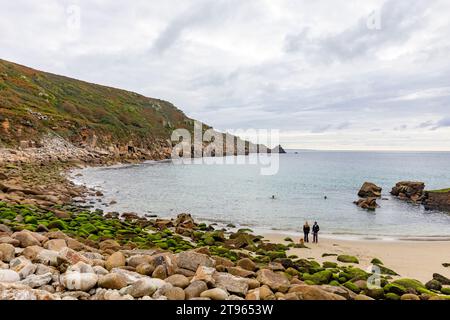 Lamorna Cove, zwei Leute gehen mit ihrem Hund am Sandstrand, Cornwall Südwesten Englands, Großbritannien, 2023 Stockfoto