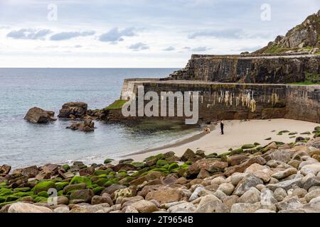 Lamorna Cove, zwei Leute gehen mit ihrem Hund am Sandstrand, Cornwall Südwesten Englands, Großbritannien, 2023 Stockfoto