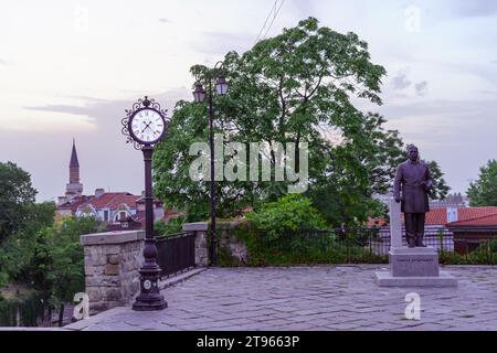 Plovdiv, Bulgarien - 24. September 2023: Blick auf den Sonnenuntergang einer Straßenuhr und der Statue von Gavril Krastewitsch in Plovdiv, Bulgarien Stockfoto