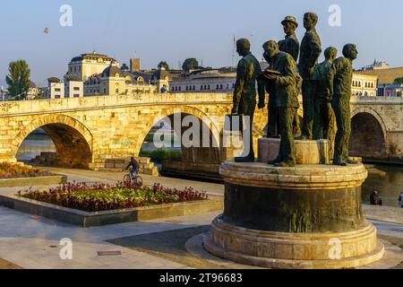 Skopje, Nordmakedonien - 5. Oktober 2023: Blick auf das Denkmal der Boote von Thessaloniki und die Steinerne Brücke, mit Einheimischen und Besuchern, in Skopje, N Stockfoto