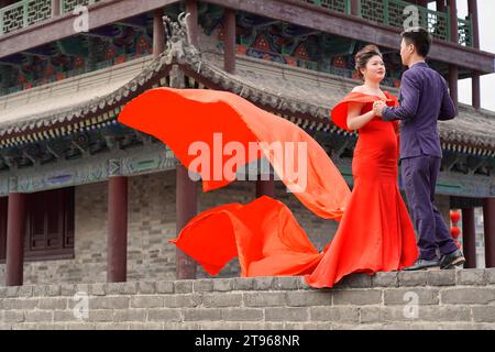 Das Hochzeitspaar stand an der Stadtmauer in Xian und die Braut und der Bräutigam stimmten dem Foto zu Stockfoto