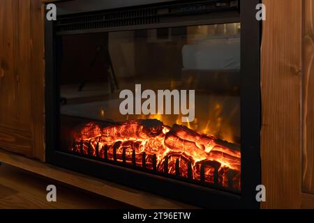 Elektrischer Kamin brennt Brennholz Nahaufnahme Hintergrund Stockfoto