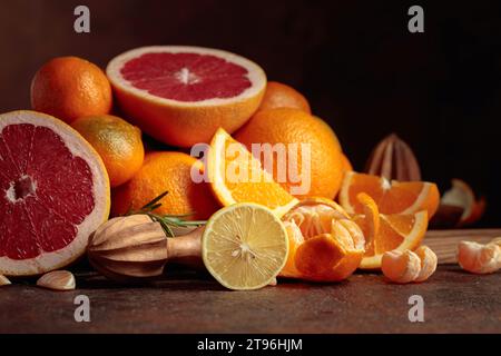 Zitrusfrüchte auf einem alten braunen Tisch. Angeboten werden Orangen, Grapefruits, Zitronen und Tangerinen. Stockfoto