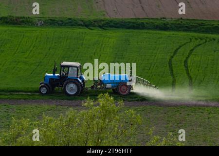 Luftaufnahme des Traktors, der auf grünen Feldern mit Pestiziden sprüht. Stockfoto