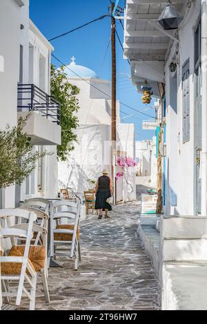 Ältere Frau, schwarz gekleidet, geht in einer typischen Gasse des Dorfes Chorio, Kimolos Stockfoto