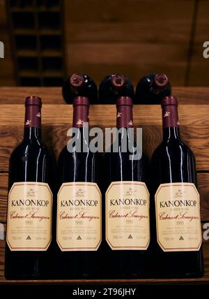 Die Flaschen Kanonkop Wein auf einem Holzregal, vor einem hölzernen Hintergrund Stockfoto