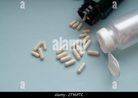 Arzneimittelpillen und -Kapseln, die aus der Pillenflasche verschüttet werden. Stockfoto