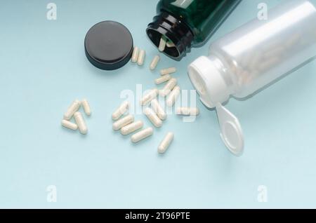 Arzneimittelpillen und -Kapseln, die aus der Pillenflasche verschüttet werden. Stockfoto