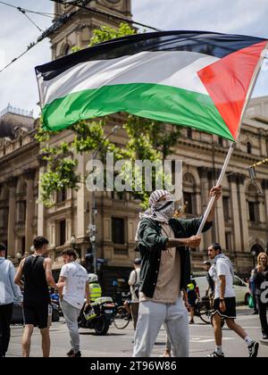 Melbourne, Australien. November 2023. Eine palästinensische Flagge wird an der Spitze des protestmarsches geschwenkt. Hunderte von Schülern der Grund- und Sekundarstufe nehmen an einem „Schulstreik“ Teil, der aus dem Unterricht geht und sich im Stadtzentrum trifft, um ihre Solidarität mit der palästinensischen Sache auszudrücken und ein Ende des israelisch-Hamas-Krieges zu fordern. Credit: SOPA Images Limited/Alamy Live News Stockfoto