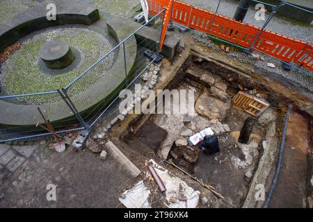 23. November 2023, Sachsen-Anhalt, Magdeburg: Holger Grönwald, Archäologe und Grabungsleiter des Landesamtes für Denkmalpflege und Archäologie Sachsen-Anhalt, untersucht Mauerreste in einer Grabungsgrube neben einer Adaption eines prächtigen Gebäudes aus dem 12. Jahrhundert. Der Domplatz in Magdeburg war in den letzten Jahrzehnten Gegenstand mehrerer archäologischer Untersuchungen. Jetzt haben Forscher zum ersten Mal Betonreste von Mauern entdeckt, die etwa 1000 Jahre auf die Zeit der ottonischen Herrscher zurückgehen. Die Überreste stammen von der äußeren Wand eines Halbzirers Stockfoto