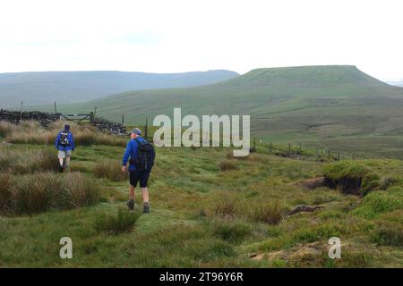 Two Men (Wanderer) laufen zu Little Whernside auf dem Fußweg zum Scar House in Nidderdale von Arkleside in Coverdale, Yorkshire Dales National Park. Stockfoto