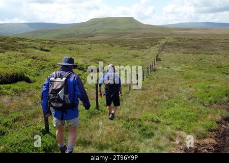 Two Men (Wanderer) laufen zu Little Whernside auf dem Fußweg zum Scar House in Nidderdale von Arkleside in Coverdale, Yorkshire Dales National Park. Stockfoto