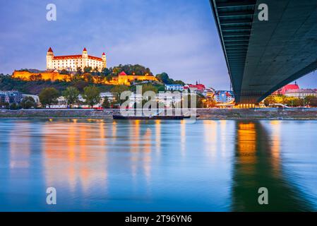 Bratislava, Slowakei. Schloss Bratislava und Altstadt über der Donau, Sonnenuntergang in der Dämmerung. Stockfoto
