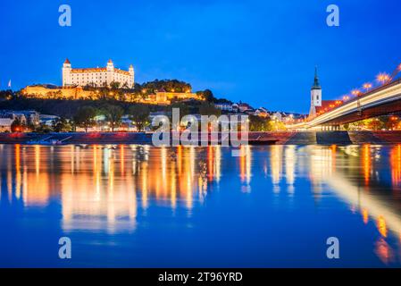 Bratislava, Slowakei. Schloss Bratislava und Altstadt über der Donau, Sonnenuntergang in der Dämmerung. Stockfoto