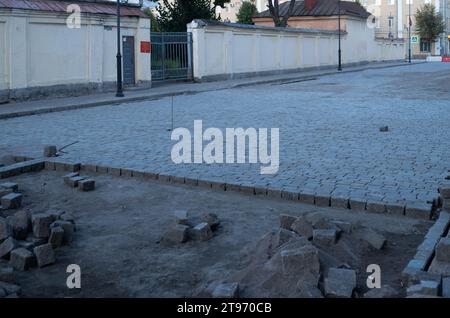 Verlegung von Pflasterplatten auf einem zu reparierenden Bürgersteig Stockfoto