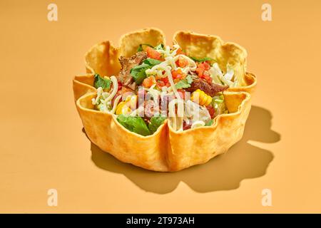 Taco-Salat in Tortilla-Schüssel mit Rind, Käse, Mais und Salat. Stockfoto