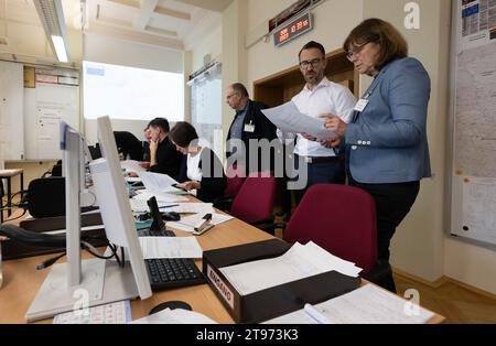 23. November 2023, Sachsen-Anhalt, Halle (Saale): Teilnehmer einer Katastrophenschutzübung treffen sich im Lagezentrum der Landesverwaltung in Halle/Saale. Zusammen mit der Stadt Magdeburg und dem Landkreis Anhalt-Bitterfeld trainieren rund 180 Teilnehmer in zwei Schichten im Umgang mit einem Hochwasserszenario. Im fiktiven Szenario haben wochenlange Regenfälle hohe Wasserstände an Mulde und Elbe verursacht. Das Landesamt für Hochwasserschutz und Wasserwirtschaft erklärt die Alarmstufe vier, während die Landeshauptstadt und der Bezirk den Ausnahmezustand ausrufen. Der Fokus Stockfoto