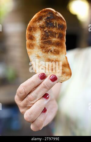 Die Frau hält ein Stück Toast vom Grill Stockfoto