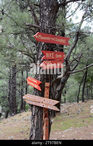 Schilder entlang des Chalaris Canyon Wanderweges im Wald auf der griechischen Insel Ikaria, in der Nähe des Dorfes NAS, Griechenland. Stockfoto