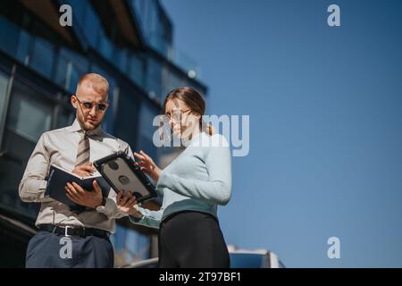 Ein Unternehmensteam diskutiert Geschäftsstrategien für globale Expansion und Rentabilität in einem geschäftigen städtischen Umfeld. Stockfoto