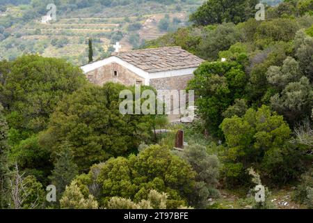 Eine kleine orthodoxe christliche Kirche oder Kapelle in den Hügeln und Wäldern oberhalb der Stadt Evdilos auf der griechischen Insel Ikaria, Griechenland. Stockfoto