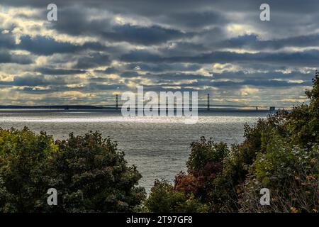 Die Mackinac-Brücke überspannt die Straits of Mackinac zwischen der Unteren und Oberen Halbinsel Michigans, fotografiert von der bewaldeten West Bluff Road. Mackinac Island, Michigan, Vereinigte Staaten. Stockfoto