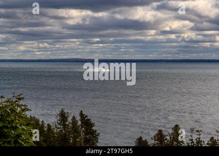 Ein Shepler's Ferry Schnellboot hinterlässt eine Spur von Gischt auf den Straits of Mackinac, fotografiert von der West Bluff Road. Die Überquerung zwischen dem Festland und der Insel dauert etwa 15 Minuten. Mackinac Island, Michigan, Vereinigte Staaten. Stockfoto