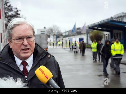 23. November 2023, Brandenburg, Fürstenwalde: Jörg Steinbach (SPD), brandenburgischer Minister für Wirtschaft, Arbeit und Energie, gibt vor dem Eingang der Goodyear-Reifenfabrik ein Interview, als Mitarbeiter das Werk nach einer Werkssitzung verlassen. Nach der Ankündigung des Unternehmens, 750 Arbeitsplätze am Standort Fürstenwalde abzubauen, nahm der betriebsrat Goodyear während der Sitzung Stellung. Foto: Soeren Stache/dpa Stockfoto