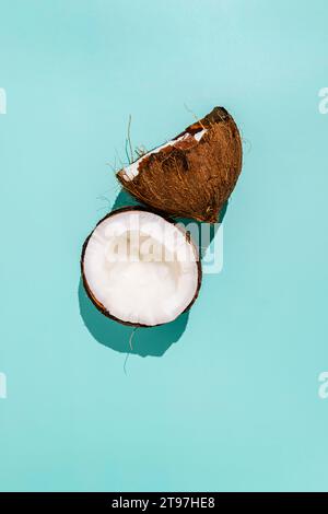 Gebrochene Kokosnuss auf blauem Hintergrund Stockfoto