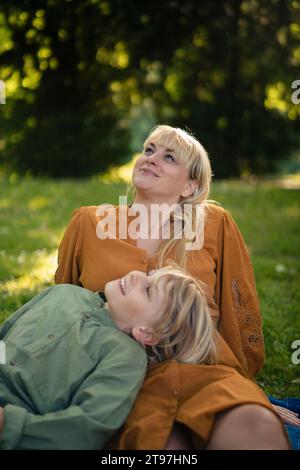 Glückliche Mutter und Sohn, die sich im Park entspannen Stockfoto