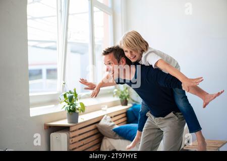 Glücklicher Vater, der seinem Sohn einen Huckepack reitet Stockfoto