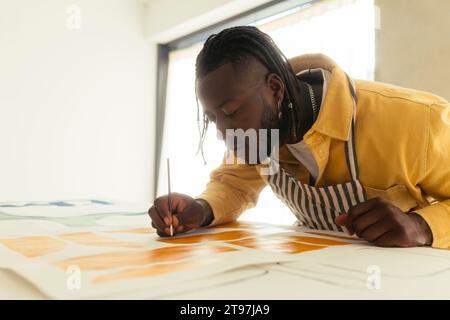 Künstlermalerei mit Pinsel auf Leinwand am Schreibtisch im Studio Stockfoto